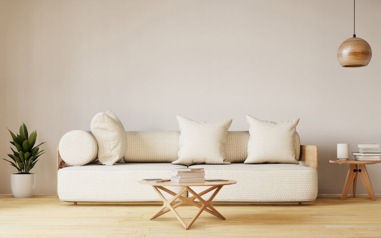 Séjour minimaliste avec un canapé beige et des éléments de décorations en bois.