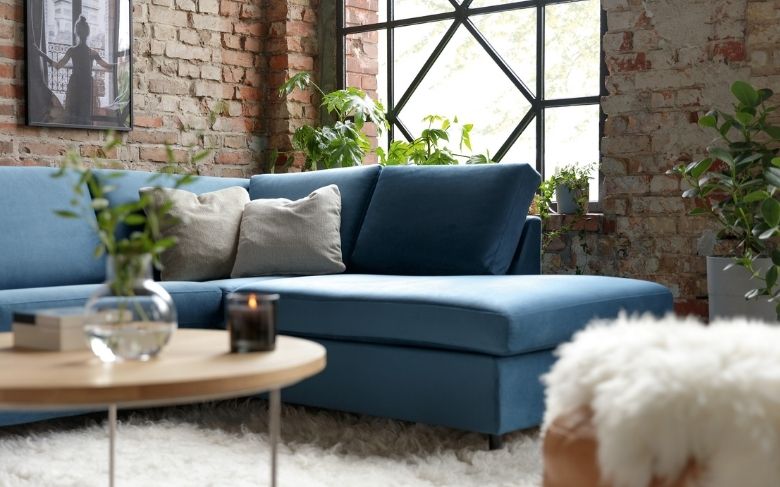 Canapé Enghien, bleu, salon au style industriel, coussins gris, tapis en fourrure, table basse en bois