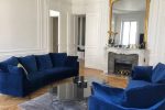 salon avec canapés bleu cheminée et grand miroir